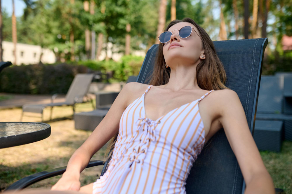 Woman resting in a lounge chair in a sunny garden